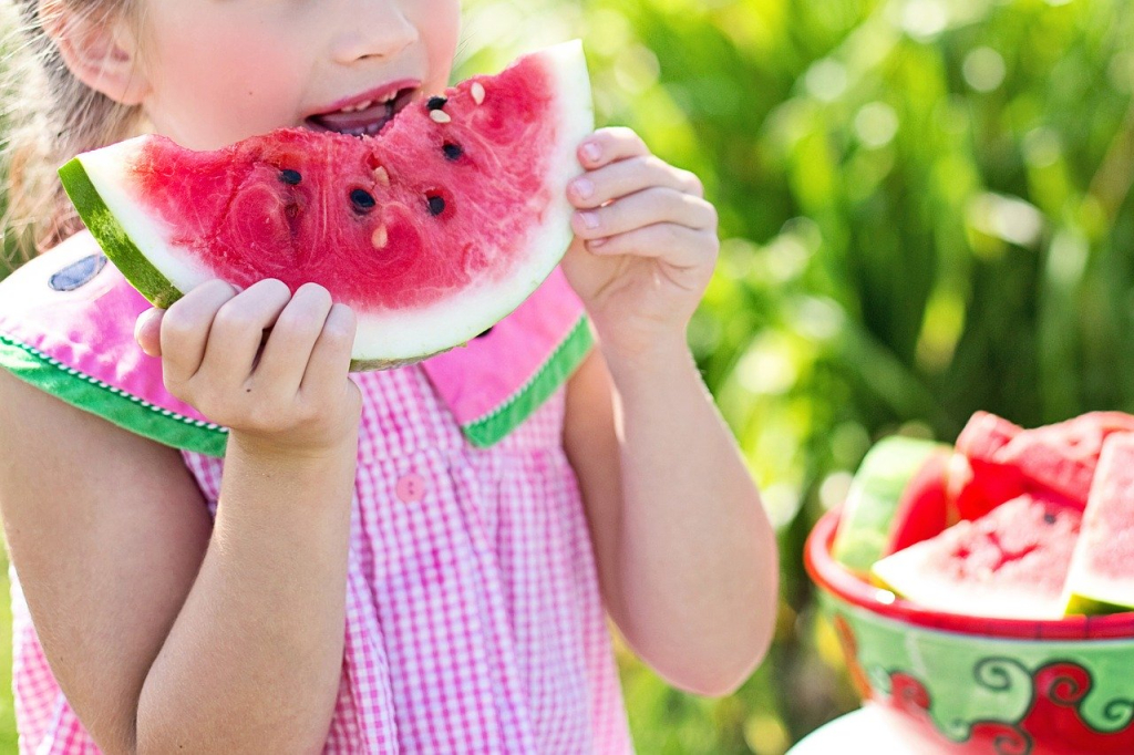 Bambina mangia una fetta di anguria